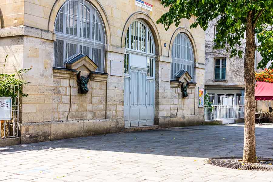 vue des fontaines sur la place derrière la halle des blancs manteaux